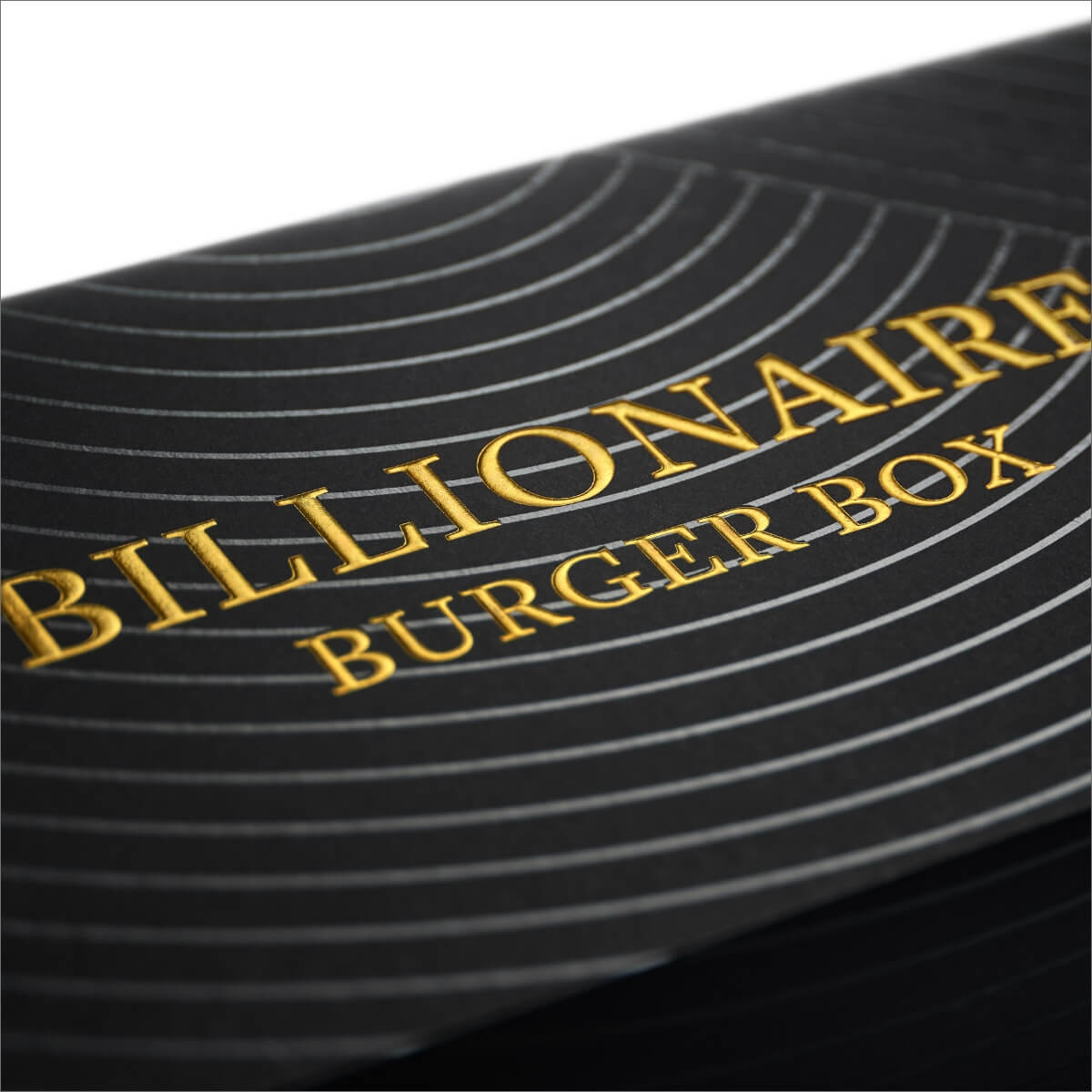 Close-up of a black box with 'Billionaire Burger Box' text in gold.