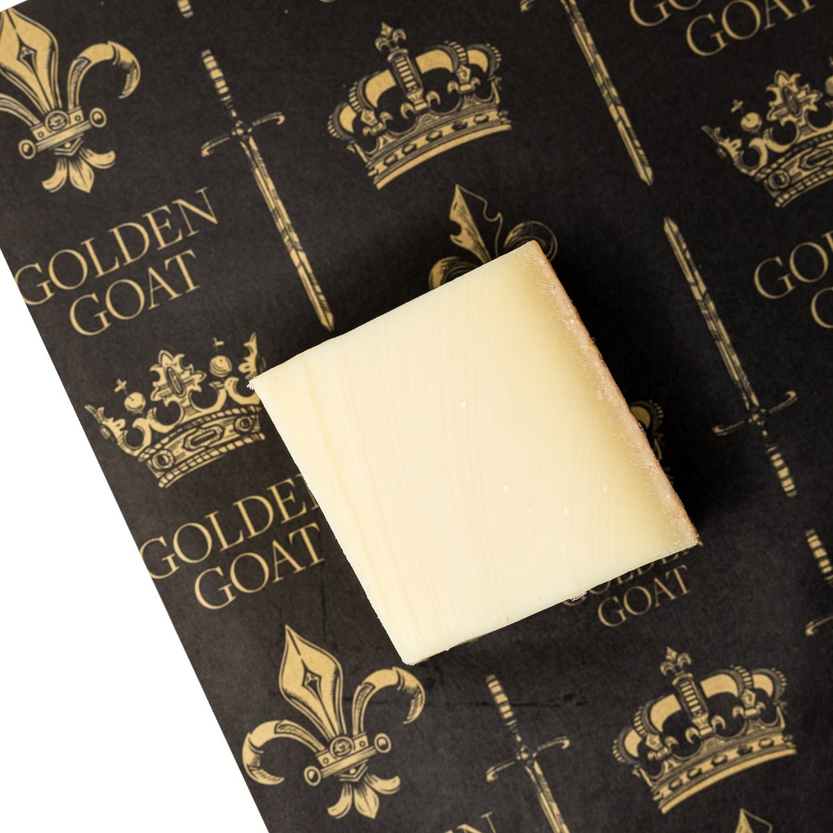 A block of cheese on a black background with a golden goat logo pattern.
