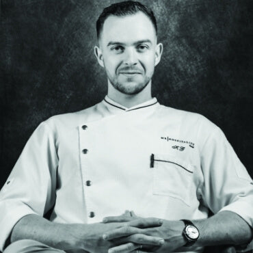 Man wearing a uniform with a logo on a dark background