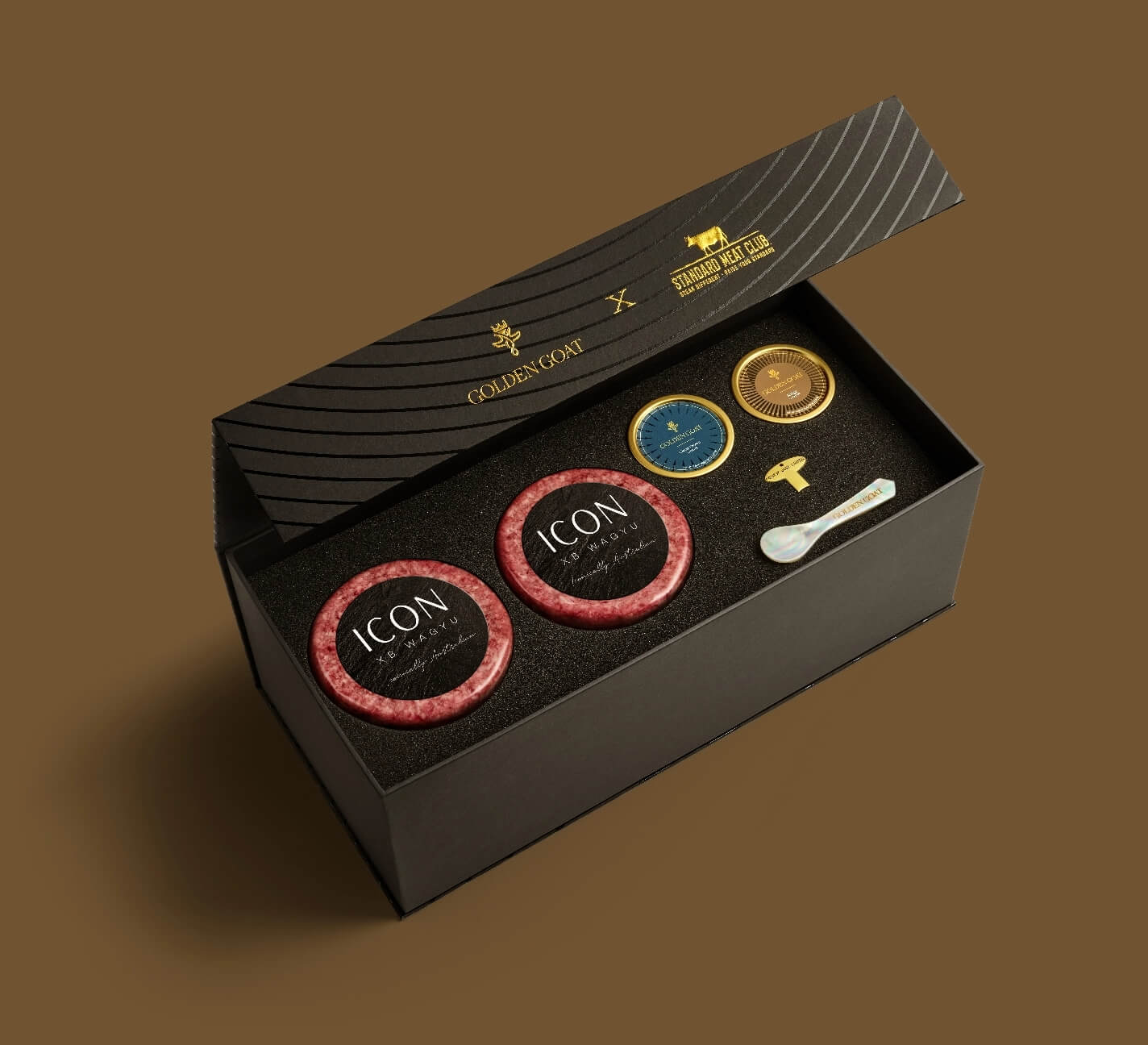 Black gift box with 'ICON' wagyu beef and a selection of caviar on a brown background.